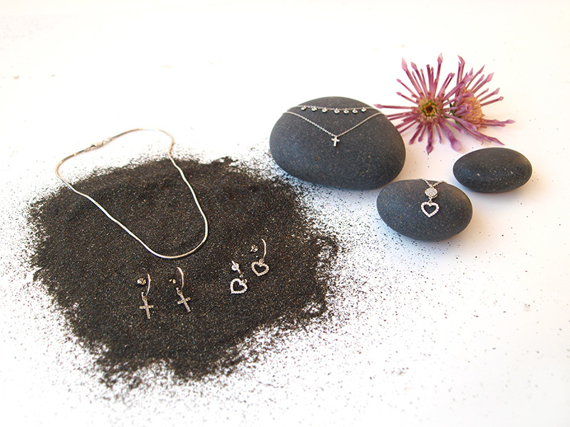 silver jewellery on black rocks and soil